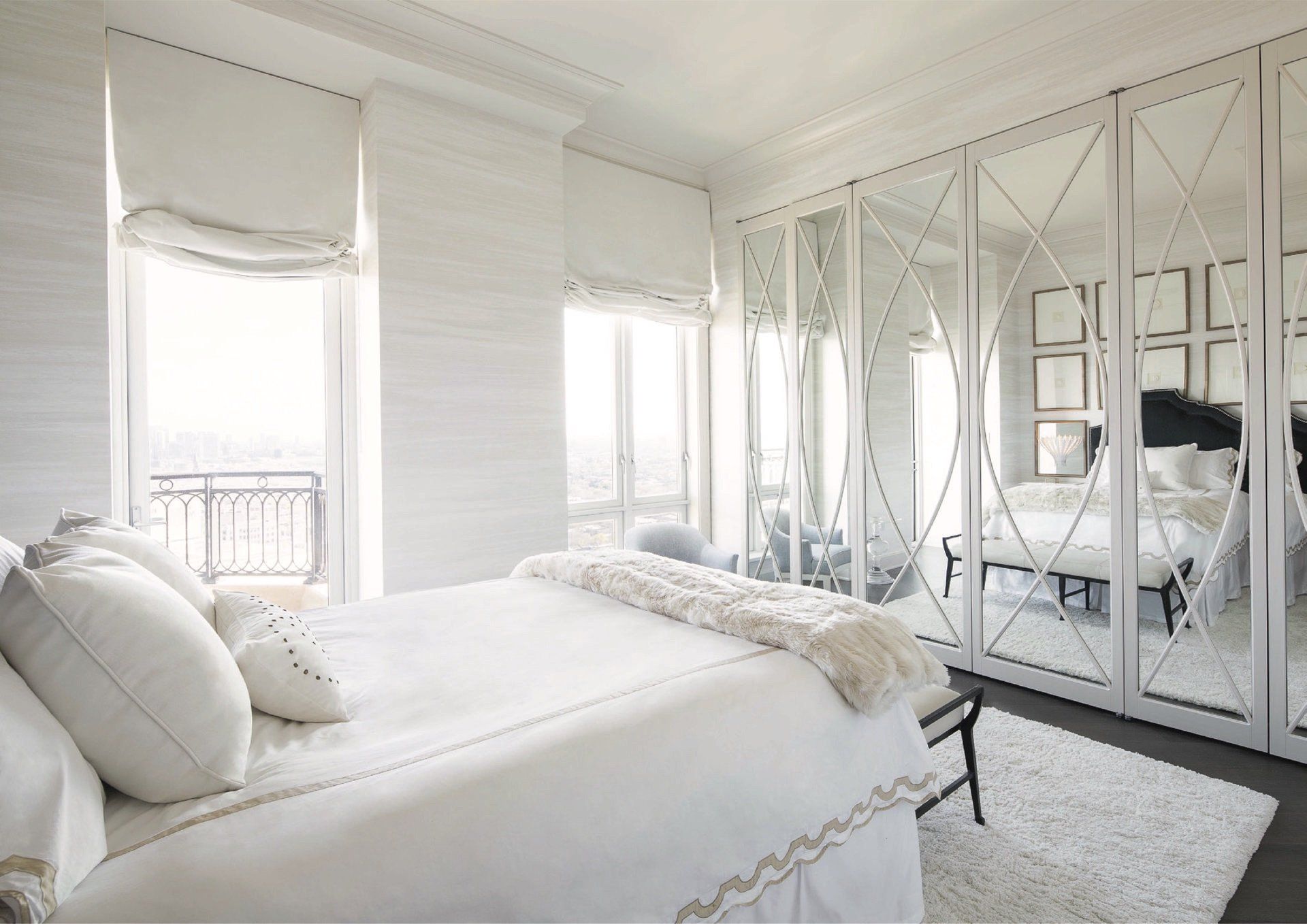 There is a large bed in the middle of the room with a lot of windows.